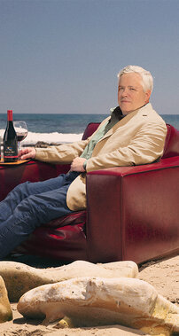 Siduri Wines winemaker, Adam Lee, sitting on the beach with wine